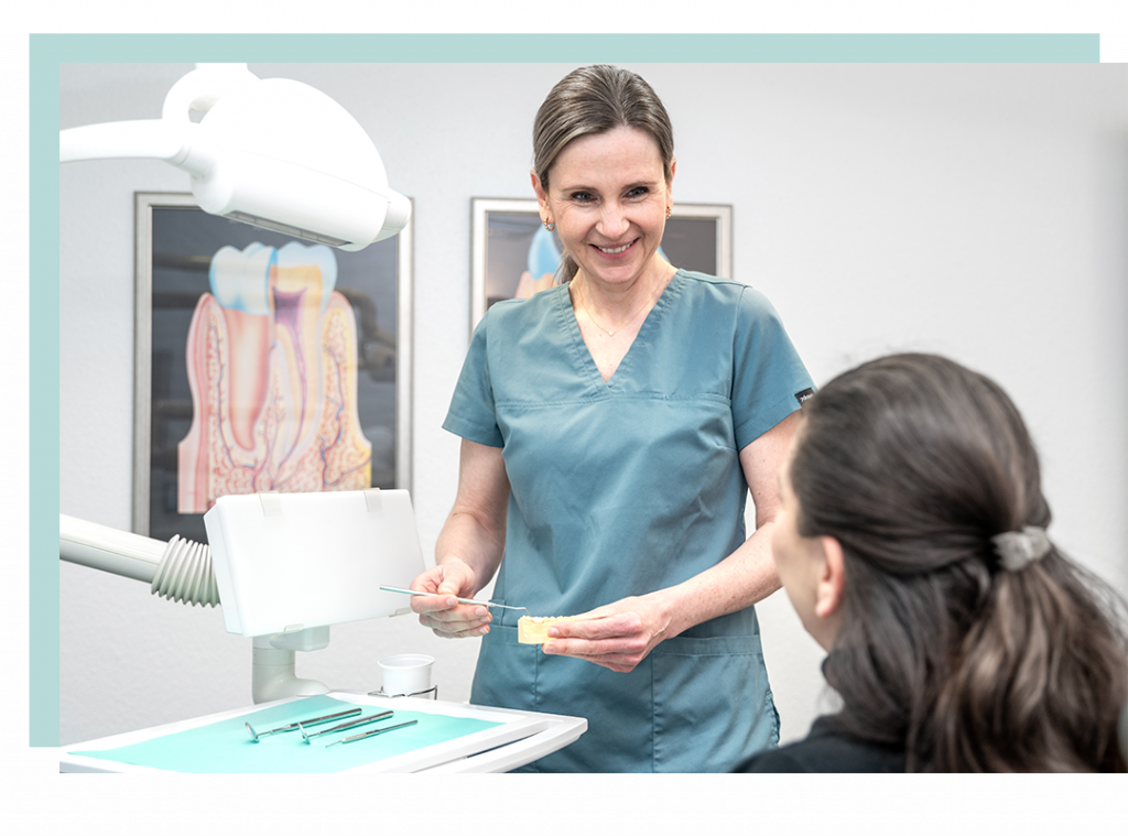 Foto von Frau Dr. Janßen in einer Beratungssituation mit einer Patientin. Sie erklärt das Vorgehen der bevorstehenden Behandlung.